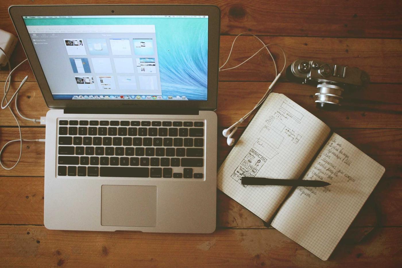 Laptop and notebook on a desk where someone reviews project income